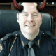 Fostoria News Police officer with devil horns filter, smiling in uniform.